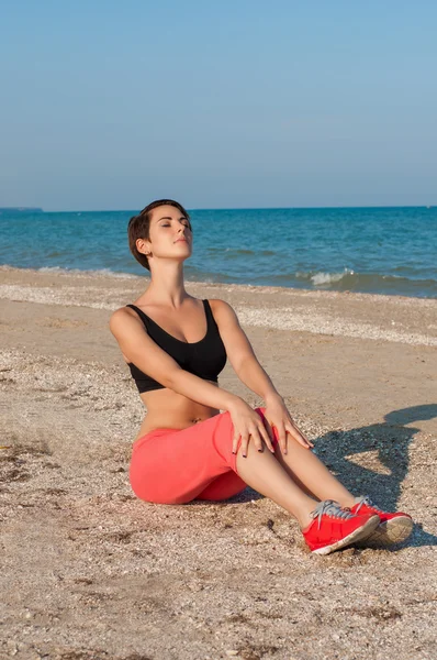 Junge schöne Sportlerin am Strand — Stockfoto