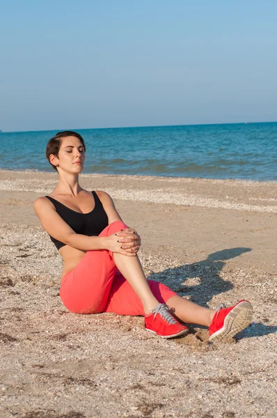 Joven hermosa chica atleta en la playa — Foto de Stock