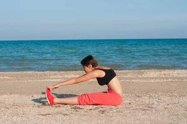 Joven hermosa chica atleta en la playa — Foto de Stock