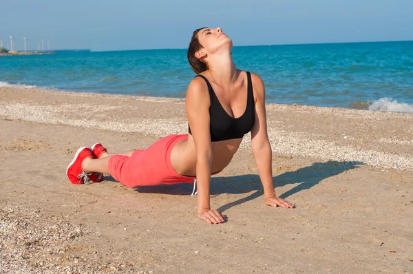 Young beautiful girl athlete on the beach — Stock Photo, Image