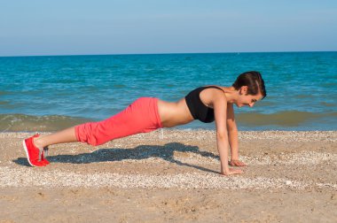 Genç güzel kız atlet sahilde