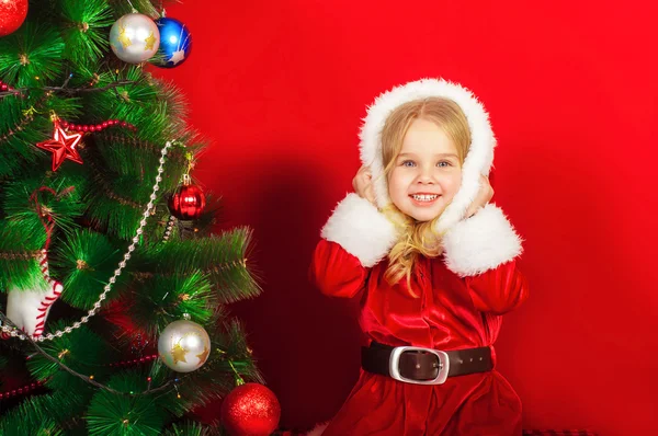 Klein meisje bij de kerstboom — Stockfoto