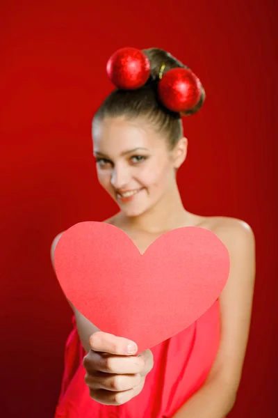 Jong meisje met een rood hart speelgoed in handen — Stockfoto