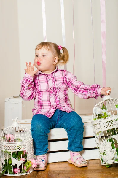 Petite fille dans une avec des cages d'oiseaux décoratives — Photo