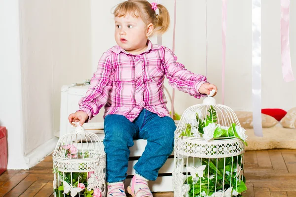 Küçük kız bir dekoratif birdcages ile — Stok fotoğraf