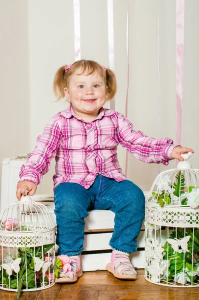 Little girl in a  with decorative birdcages — Stock Photo, Image