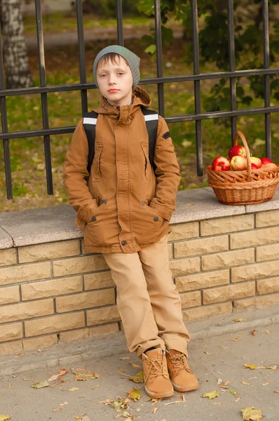 Jongen met een school rugzak met een mandje van appels — Stockfoto