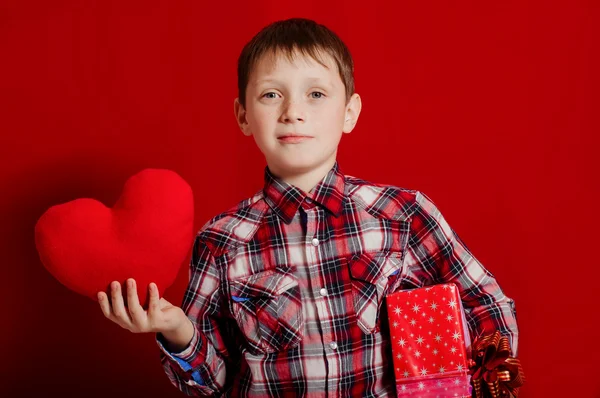 Petit garçon avec un coeur de jouet et boîte cadeau — Photo