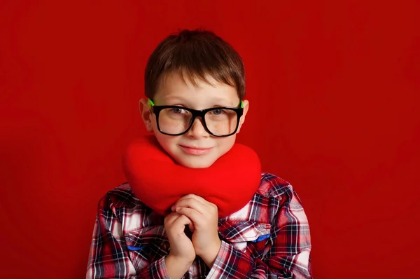 Kleine jongen in glazen met een hart van speelgoed — Stockfoto