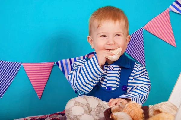 Child in blue with sea shells — Stock Photo, Image