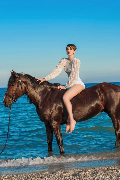 Молода красива дівчина з конем на пляжі — стокове фото