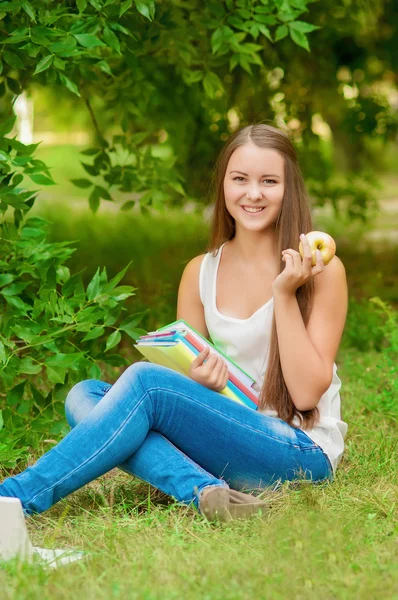 Ung student med böcker och äpple — Stockfoto