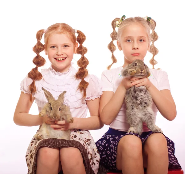Pequenas garotas com coelhos nas mãos — Fotografia de Stock