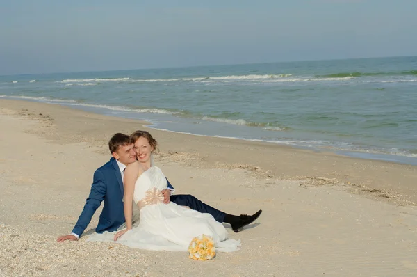 Unga bruden och brudgummen på stranden — Stockfoto