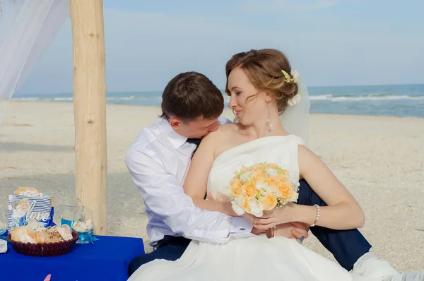 Unga bruden och brudgummen på stranden — Stockfoto
