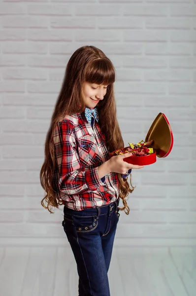 Menina com uma caixa vermelha de chocolates — Fotografia de Stock