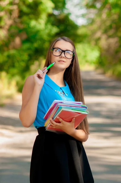 Menina adolescente com óculos e livros em mãos — Fotografia de Stock