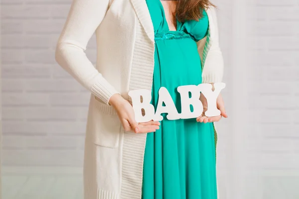 Ventre d'une femme enceinte en robe turquoise — Photo