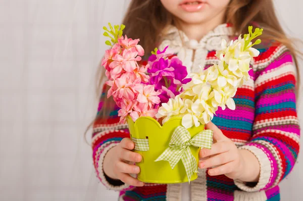 Hands of a little girl with spring flowers — Stock Photo, Image