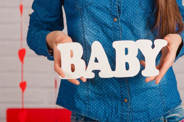 Mains d'une fille avec mot bébé — Photo