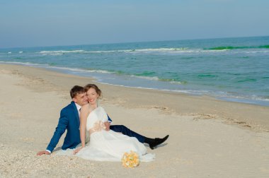 Genç gelin ve damat sahilde