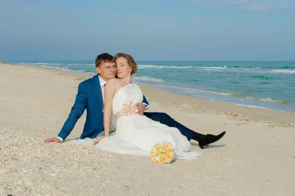 Unga bruden och brudgummen på stranden — Stockfoto