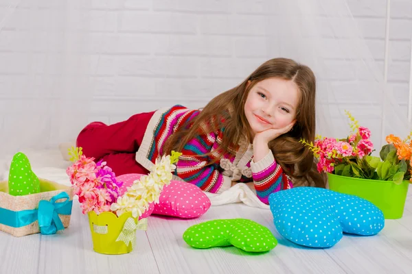 Kleines Mädchen mit Frühlingsblumen in der Vase — Stockfoto