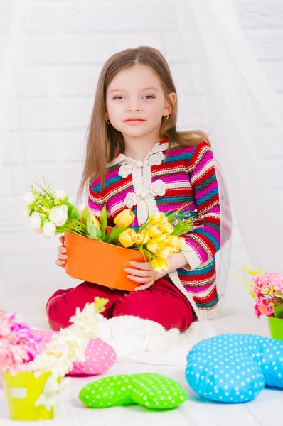 Little girl with spring flowers in  vase — Stock Photo, Image