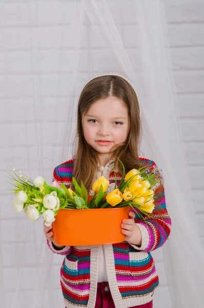 Little girl with spring flowers in  vase — Stock Photo, Image