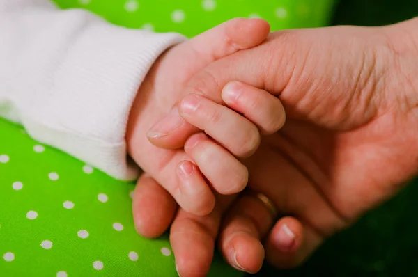 Mano de un pequeño bebé en la de la madre —  Fotos de Stock