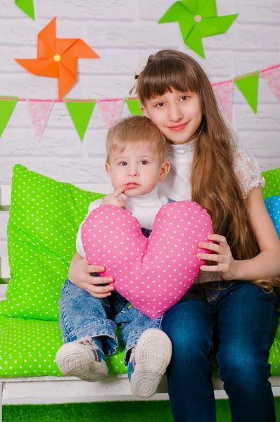 Ragazzino e una sorella maggiore sorridenti sulla panchina — Foto Stock