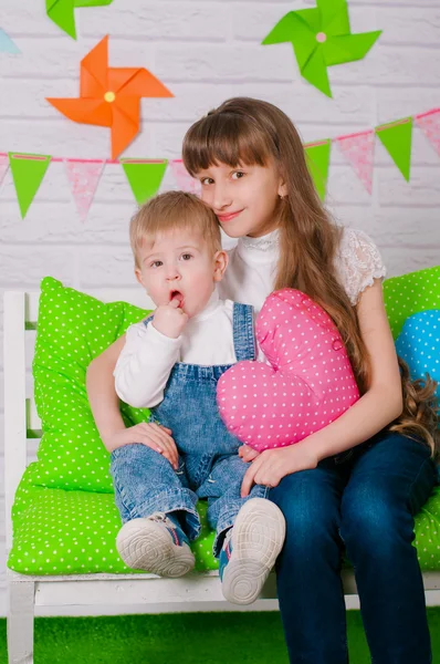 Little boy and an older sister smiling on the bench — Stock Photo, Image