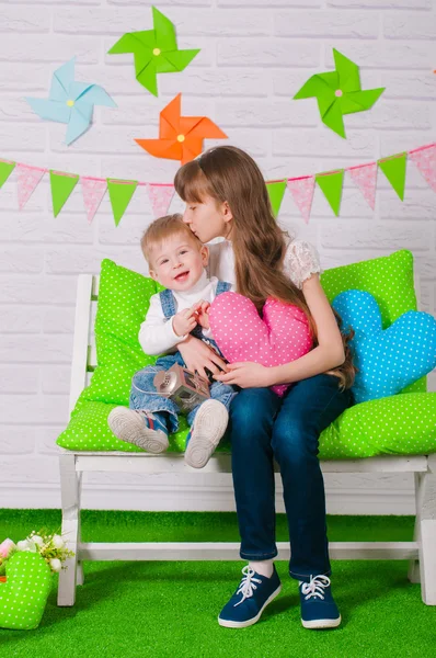 Little boy and an older sister smiling on the bench — Stock Photo, Image