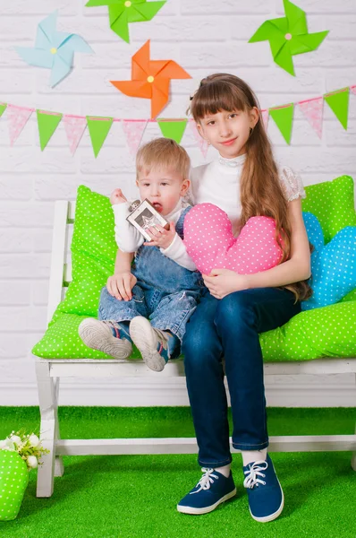 Kleine jongen en een oudere zus glimlachen op de Bank — Stockfoto