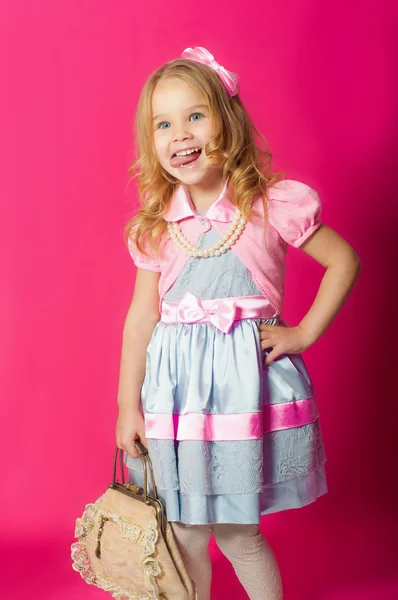 Petite fille dans une belle robe avec un sac — Photo