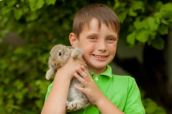 De kleine jongen met een konijn in de handen — Stockfoto