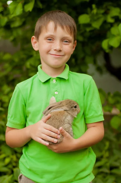 Den lilla pojken med en kanin i händerna — Stockfoto