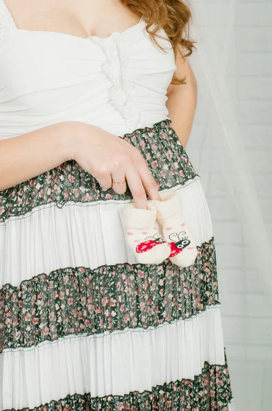 Baby socks in  hands of pregnant woman — Stock Photo, Image