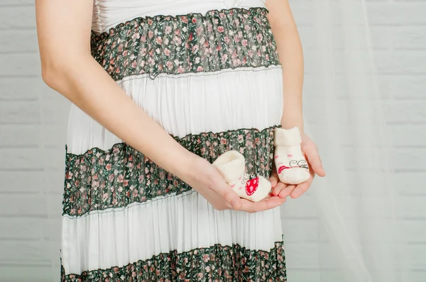 임신한 여자의 손에 아기 양말 — 스톡 사진