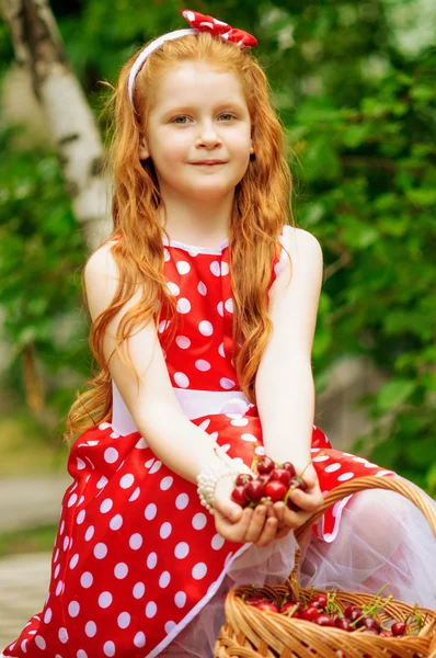 Girl in a dress with a basket of cherries — Stock Photo, Image