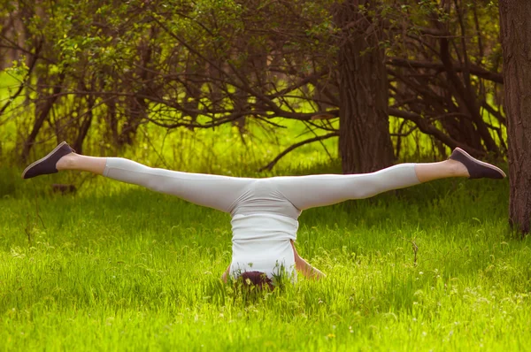 Giovane ragazza che fa yoga su un'erba verde — Foto Stock