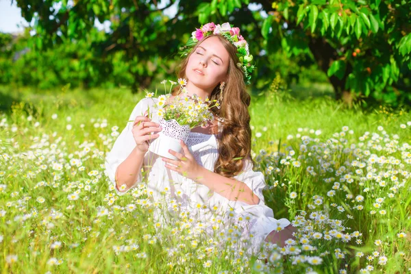 La chica con el pelo largo con una corona de margaritas en el campo — Foto de Stock