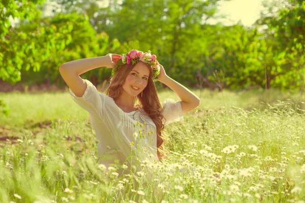 Mädchen mit langen Haaren auf dem Feld mit Gänseblümchen — Stockfoto