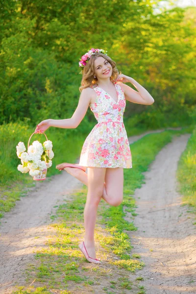 Vacker flicka med blommor på sommaren — Stockfoto