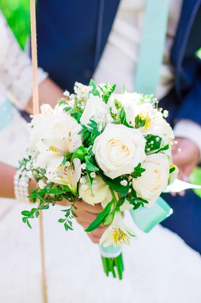 Свадебный букет и руки жениха и невесты — стоковое фото