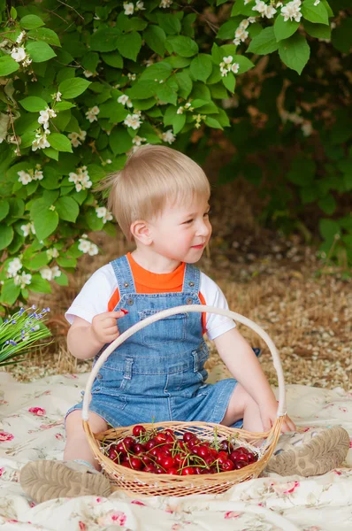 Little boy with a cherry in his hand — Stockfoto