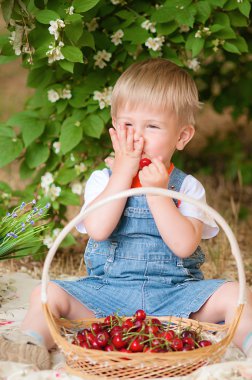 Little boy with a cherry in his hand