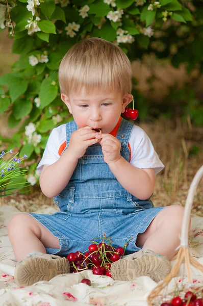 Little boy with a cherry in his hand — Stockfoto