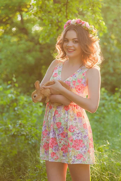 Vacker flicka med en kanin i händerna — Stockfoto