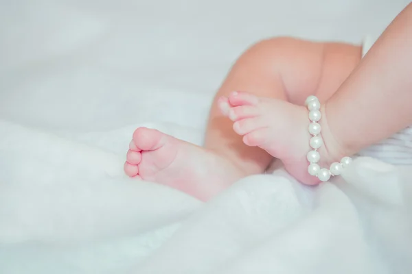 Jalat pieni vauva sängyllä — kuvapankkivalokuva